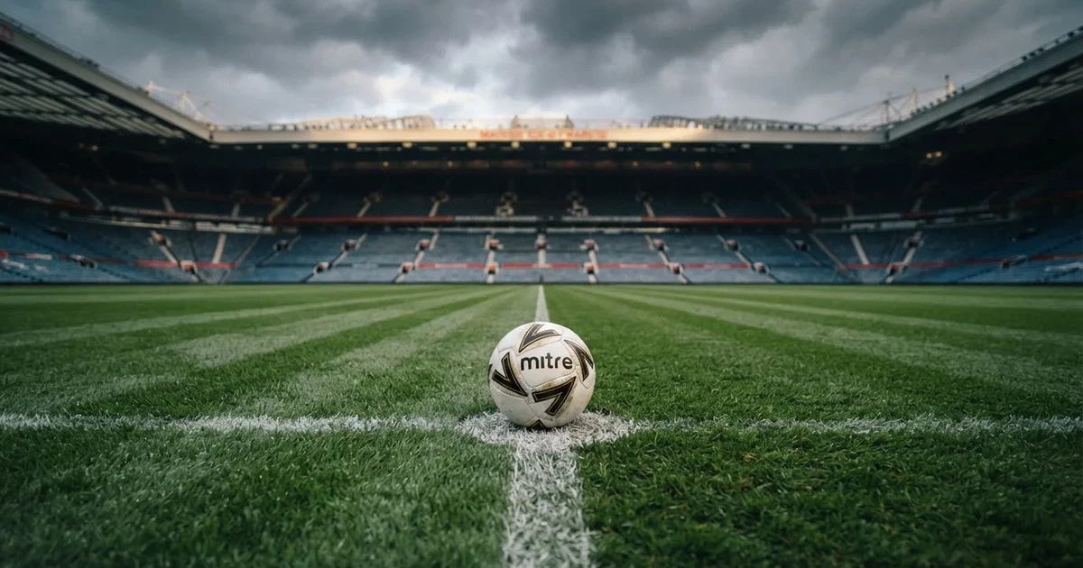Ein Fussball liegt auf dem Anstosspunkt eines frisch gemähten Rasens, dahinter eine grosse Tribüne unter bewölktem Himmel